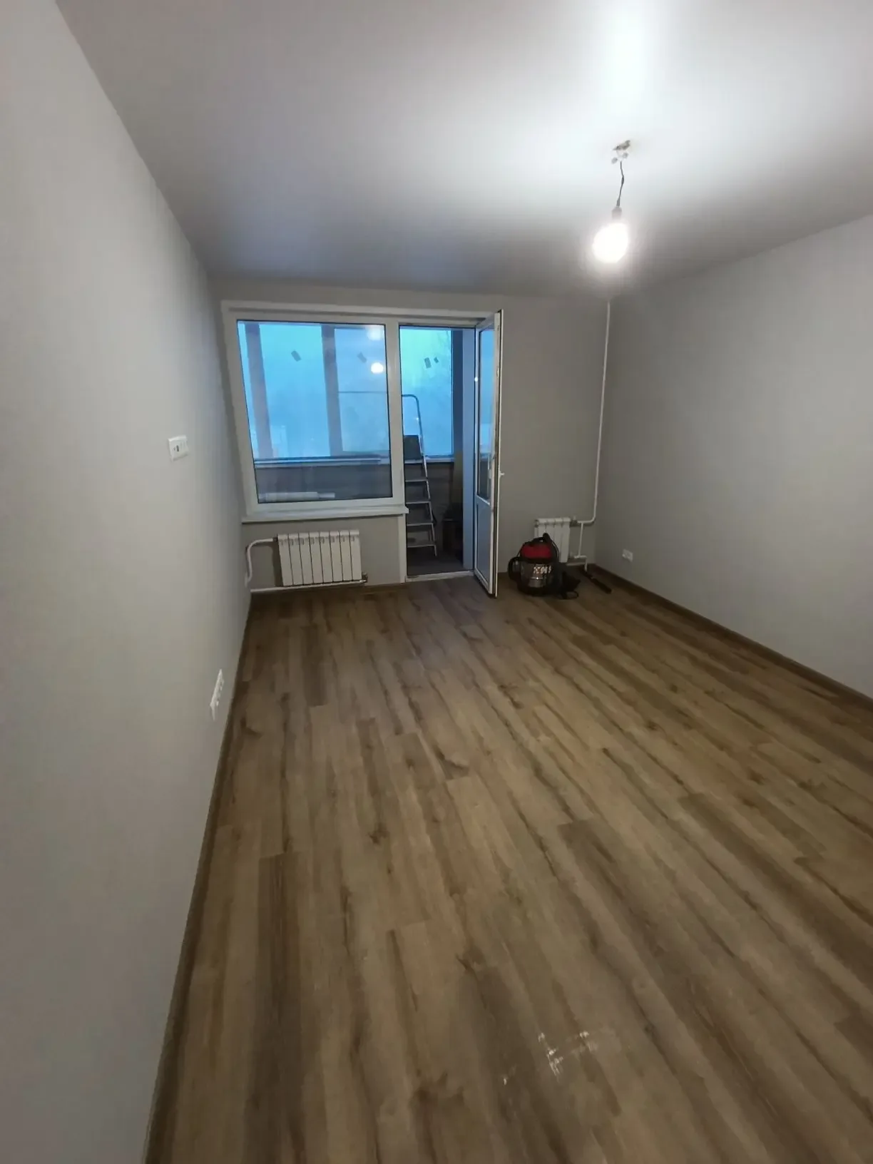 Комната после чистовой отделки — ламинат, покраска, радиаторы и розетки
